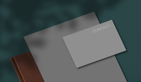 Set of stationery with empty blank grey notepad and business card for your contact or information against dark green background.